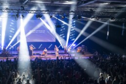 Band und Publikum werden beim Konzert angestrahlt.